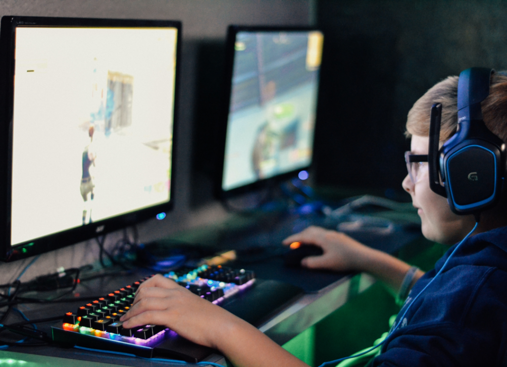 Child sitting in front of computer and playing a video game